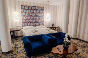 a bedroom with a bed and a blue couch at Pannonia 1893 Prémium in Sopron
