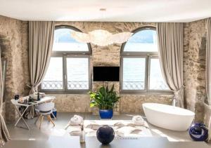 a bathroom with a large tub and windows at Relais Villa Porta in Luino