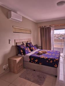 a bedroom with a bed with blue sheets and a window at Pemba's residence in Cape Town +90 photos