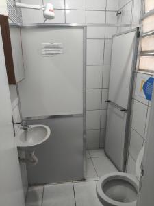 a bathroom with a shower and a toilet and a sink at Hotel Portugal in Macaé