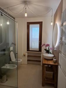 a bathroom with a sink and a toilet and a window at Podere Radici - Room & Breakfast in Misano Adriatico