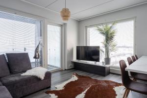 a living room with a couch and a tv at Luxurious Penthouse - Hot Tub & Sauna in Tampere +14 photos
