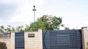 a blue fence with a gate in front of it at Zambarau house in Busia