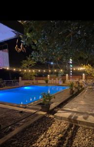 a swimming pool at night with lights around it at Hotel Ruwan in Kataragama
