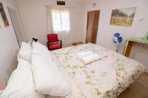 a bedroom with a bed with white pillows at Zambarau house in Busia +4 photos