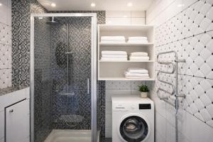 a bathroom with a shower and a washing machine at Birštono Terasos in Birštonas +20 photos