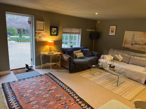 a living room with a couch and a table at Charming one bedroom cottage in Basingstoke