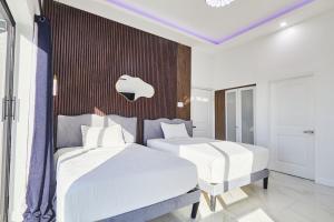 two beds in a room with an apple sign on the wall at Hillzone View in Kingston +22 photos