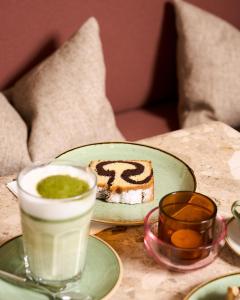 a table with a plate of cake and a cup of coffee at Hotel Karol in Vienna +7 photos