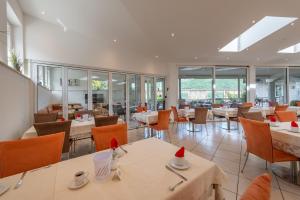 a restaurant with tables and chairs and windows at Garni Hotel Sonnleitenhof in Caldaro