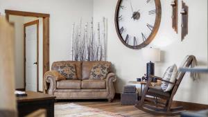 a living room with a couch and a clock on the wall at Paradise View in Red Lodge