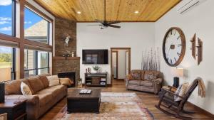 a living room with a couch and a clock on the wall at Paradise View in Red Lodge
