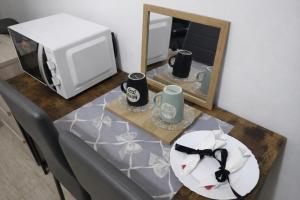 a table with a microwave and a table with a mirror at Golden Stay Rome - Golden Room - Close to Metro C in Tor Vergata