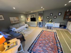 a living room with a couch and a table at Charming one bedroom cottage in Basingstoke