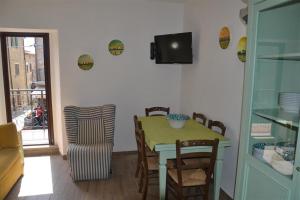 a dining room with a table and chairs and a television at Casa Tirli in Tirli +7 photos