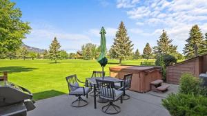 a patio with a table and chairs and an umbrella at Peaks & Par in Red Lodge