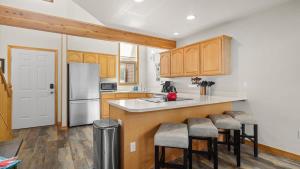 a kitchen with wooden cabinets and a white refrigerator at Peaks & Par in Red Lodge