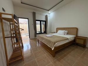 a bedroom with a bed and a wooden ladder at Gili Glow Homestay in Gili Trawangan