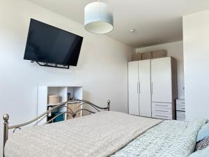 a bedroom with a bed with a flat screen tv on the wall at Ferienwohnung in Neudenau