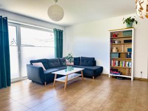 a living room with a blue couch and a table at Ferienwohnung in Neudenau