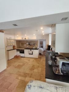 a large kitchen with white cabinets and a wooden floor at Land - Haus in Pusterwald