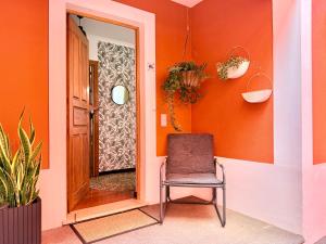 a chair in a hallway with an orange wall at The Pink Villa - Holidays in Madeira Island in Caniço
