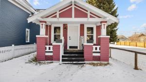 a pink house with a white door in the snow at Rio Ridge in Red Lodge