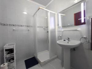 a white bathroom with a shower and a sink at Paraíso Verde in Algarvia +32 photos