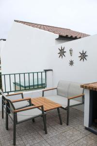 a patio with a couch and a table and chairs at Paraíso Verde in Algarvia