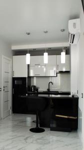 a kitchen with a black counter and white cabinets at Апартаменты Сонячний квартал in Golubinoye