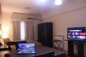 a living room with a laptop on a table and a television at Antares Apartments in Campana