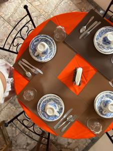 a table with plates and utensils on it at Pertinho do CENTRO - Hospedaria Vila Rica - Excelente Custo Benefício in Ouro Preto +28 photos