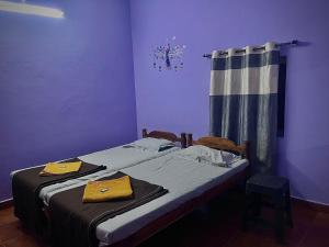 a bedroom with two twin beds and a curtain at Aarvi Residency in Māvalli +2 photos