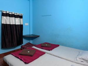 a blue room with two beds with mats on them at Aarvi Residency in Māvalli