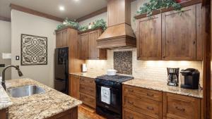 a kitchen with wooden cabinets and a black stove top oven at Rock Creek Escape in Red Lodge