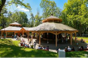 a group of people sitting in a pavilion in a park at Apartament in Rabka-Zdrój
