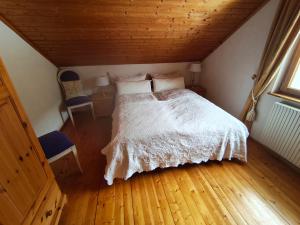 a bedroom with a white bed and a wooden floor at Land - Haus in Pusterwald
