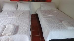 two beds sitting next to each other in a room at Hacienda Torcoroma in Bucaramanga