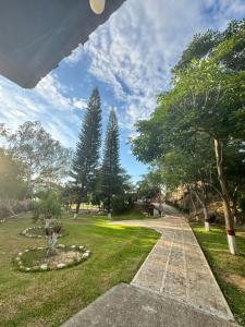 a walkway in a park with trees and grass at Hacienda Torcoroma in Bucaramanga