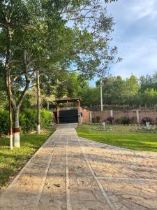 a walkway in a park with trees and a building at Hacienda Torcoroma in Bucaramanga +2 photos