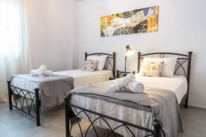 a bedroom with two beds with stuffed animals on them at Casa Anavyssos in Anavyssos +20 photos