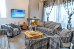 a living room with couches and a fireplace at Casa Anavyssos in Anavyssos