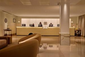 a lobby with a waiting room with people sitting in computers at The May Fair Hotel, Mayfair, London in London