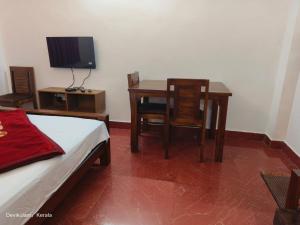 a room with a table and a table and chairs at Rose Cottage in Devikolam