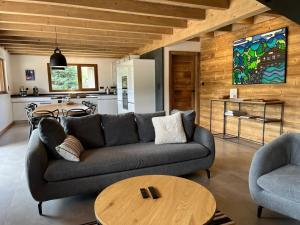 a living room with a couch and a table at Chalet Les Roitelets 5 étoiles avec jacuzzi sauna in Gérardmer
