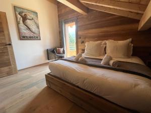a bedroom with a large bed in a room with wooden walls at Chalet Les Roitelets 5 étoiles avec jacuzzi sauna in Gérardmer
