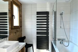 a bathroom with a sink and a shower and a tub at Chalet Les Roitelets 5 étoiles avec jacuzzi sauna in Gérardmer +31 photos