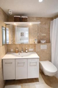a bathroom with a white sink and a toilet at Land - Haus in Pusterwald +5 photos