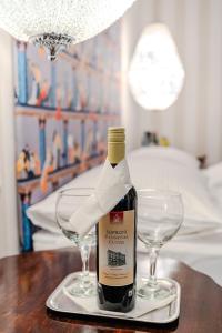 a bottle of wine sitting on a table with two glasses at Pannonia 1893 Prémium in Sopron +49 photos