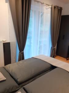 a bed in a room with a window with curtains at 100pro-Apartments in Detmold